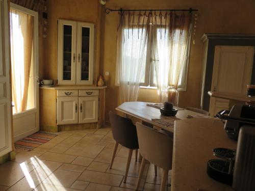 une cuisine avec une table et des chaises dans une pièce dans l'établissement Villa fiora classée 4 étoiles, à Martigues
