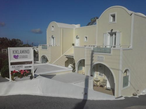 a large white building with a sign in front of it at Kiklamino Sunset Studios in Oia