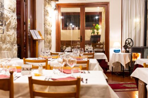 a dining room with tables and chairs with white tablecloths at Hotel Ristorante Il Caminetto in Diano Marina