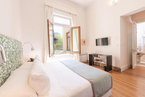um quarto com uma grande cama branca e uma janela em Cassa Lepage Art Hotel Buenos Aires em Buenos Aires