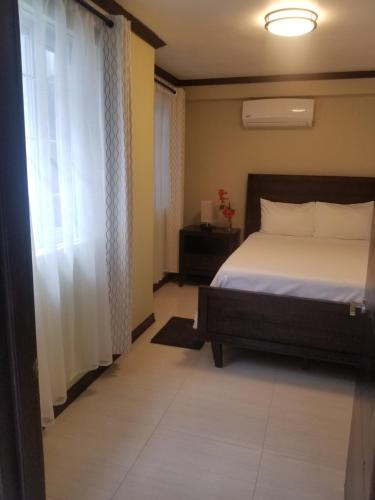 a bedroom with a bed and a window at Inn The Town in Port Antonio