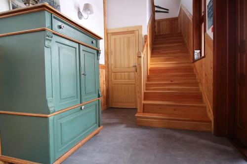 a green cabinet in a hallway with stairs at Willa Ubocz in Zakopane