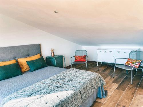 une chambre avec un lit et deux chaises dans l'établissement LE BELVEDERE, à LʼIsle-sur-la-Sorgue