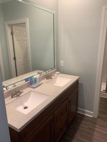 a bathroom with a sink and a large mirror at Cottages and Suites at River Landing in Wallace