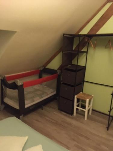 Cette chambre mansardée dispose de lits superposés et d'une échelle. dans l'établissement Calme & Accueillant, à Grandfresnoy