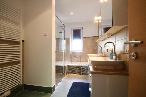ein Badezimmer mit einer Dusche, einem Waschbecken und einer Badewanne in der Unterkunft Haus Magdalena in Piesendorf