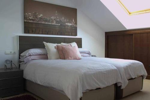 um quarto com uma cama grande e almofadas cor-de-rosa em JaimeSuite Ático Vistas al mar em Caleta de Velez