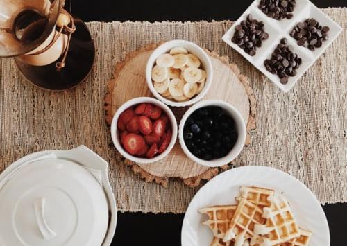 a table with waffles and other food on it at Leslie Hotel Ocean Drive in Miami Beach