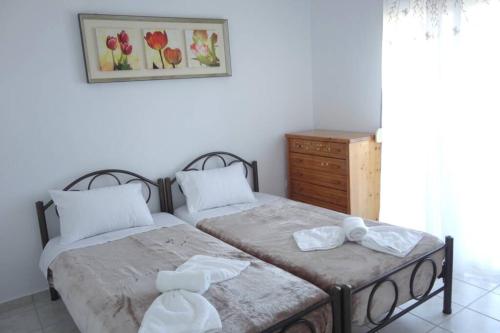 a bedroom with two beds and a dresser at Petra's House in Polychrono