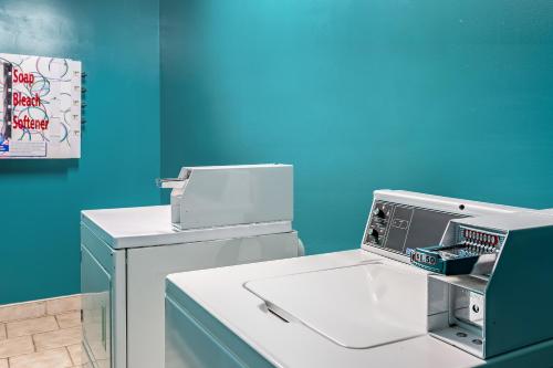 a washing machine with a blue wall in a room at Americas Best Value Inn - Temple in Temple