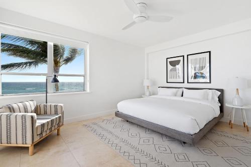 棕櫚灘的住宿－The Ambassador Hotel，卧室配有床、椅子和窗户。