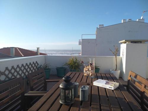 a wooden table on a balcony with a view of the ocean at Casas dos Seixos in Moledo