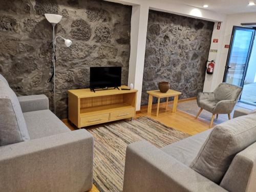 a living room with two couches and a tv at Casa do António Júlio in São Roque do Pico