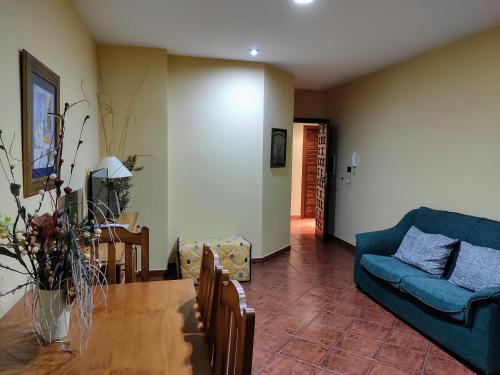 ein Wohnzimmer mit einem Tisch und einem blauen Sofa in der Unterkunft La Garzona in Losar de la Vera
