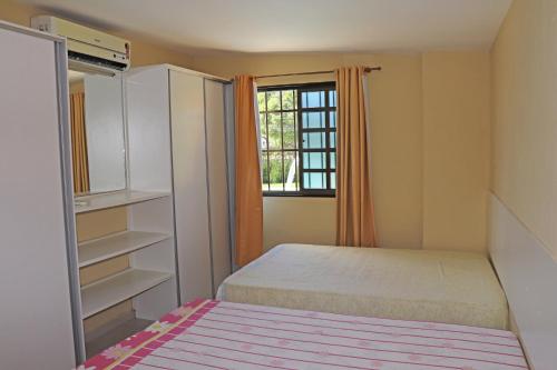 a small bedroom with a bed and a window at Casa Verde in Porto De Galinhas