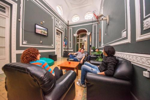a group of people sitting in chairs in a room at Hostel Alvear in Córdoba