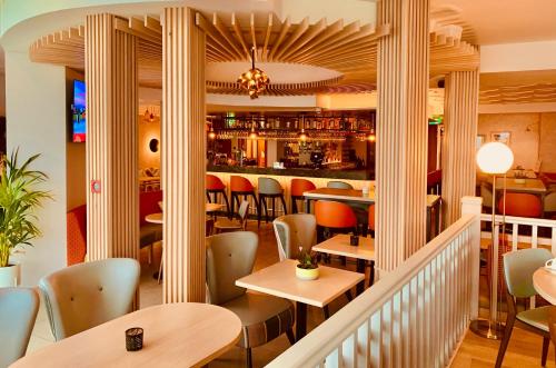 a restaurant with tables and chairs and a bar at Bayview Hotel in Bushmills