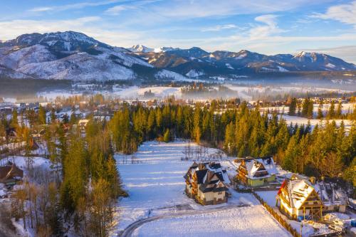 an aerial view of a town in the snow with mountains at Willa Na Polanie z Jacuzzi in Kościelisko