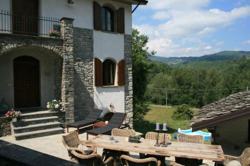 a patio with a table and chairs and a building at Casale delle farfalle in Tornolo