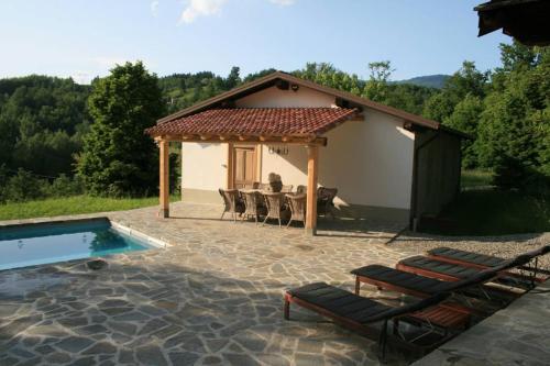 a patio with a table and chairs next to a house at Casale delle farfalle in Tornolo