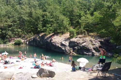 a group of people on a beach in the water at Casale delle farfalle in Tornolo