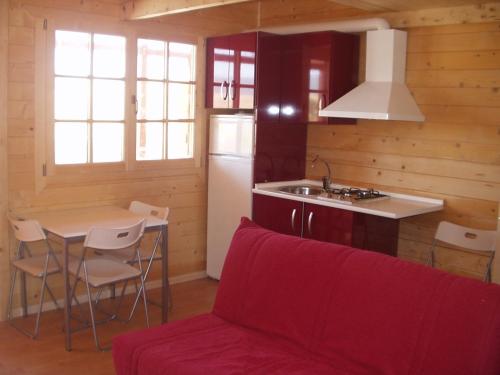 sala de estar con sofá y cocina con mesa en Maryvacas Rural en La Zarzuela