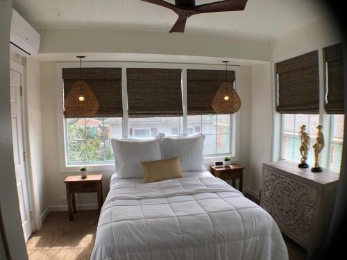 una camera da letto con un grande letto bianco e finestre di Avenue O Bed and Breakfast a Galveston