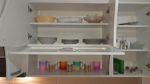 a kitchen with cups and plates and a sink at Exclusive in Paraćin
