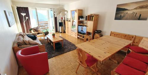a living room with a wooden table and chairs at Perle de Leysin in Leysin