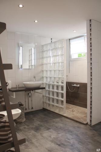 La salle de bains blanche est pourvue d'un lavabo et d'une baignoire. dans l'établissement Les coeurs de Cachemire, à Breuschwickersheim