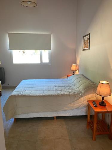 a bedroom with a large bed with two lamps and two tables at Hotel y Cabañas Las Marías in El Calafate
