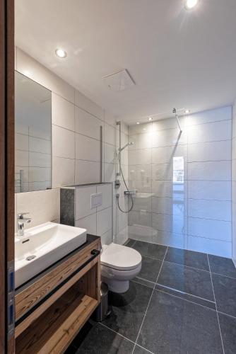 a bathroom with a toilet and a sink and a shower at Apart Alpengenuss in Ladis