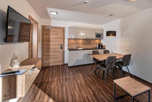 a kitchen and dining room with a table and chairs at Apart Alpengenuss in Ladis