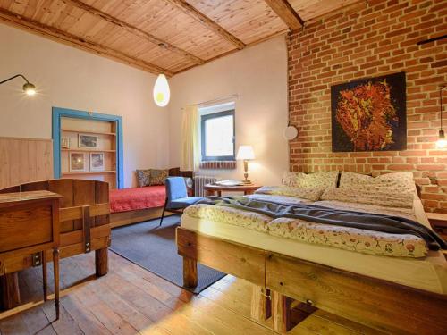 a bedroom with a bed and a brick wall at Koko Ryku Agroturystyka in Nowa Ruda