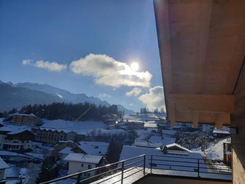a view from a balcony of a town in the snow at Apart Alpengenuss in Ladis