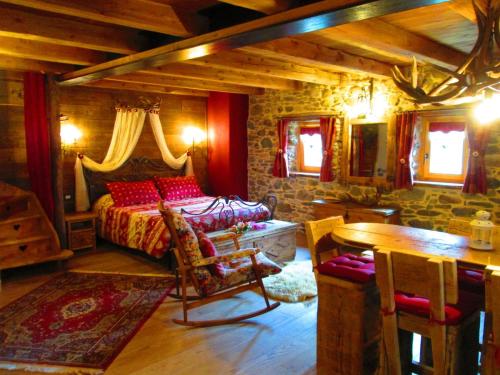 1 dormitorio con 1 cama y 1 mesa en una habitación en Chalet Cuore Selvatico, en Monno