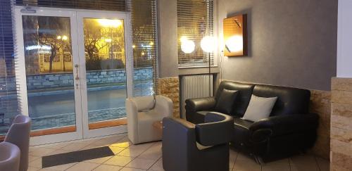 ein Wohnzimmer mit 2 Stühlen und einem Pool in der Unterkunft Hotel Anastasia in Volos