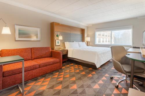 una camera d'albergo con letto e divano di Holiday Inn Philadelphia South-Swedesboro, an IHG Hotel a Swedesboro