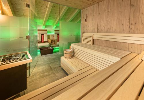 una sauna con paneles de madera e iluminación verde en Apart Alpengenuss, en Ladis