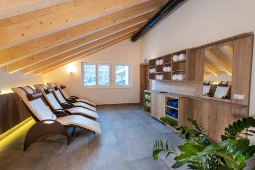 a room with a bunch of chairs and wooden ceilings at Apart Alpengenuss in Ladis