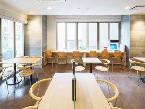 a classroom with tables and chairs and windows at Super Hotel Midosujisen Esaka in Suita
