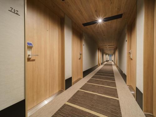 a hallway of a building with wooden walls and a long aisle at Super Hotel Midosujisen Esaka in Suita
