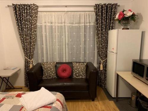 uma sala de estar com um sofá e uma almofada vermelha em Ascot Comfort em Perth