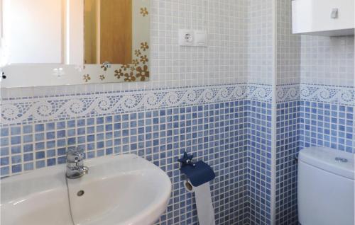 baño de azulejos azules con lavabo y aseo en Gorgeous Home In Miami Platja With Outdoor Swimming Pool, en Les Planes del Rei