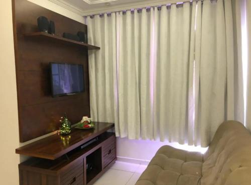 a living room with a couch and a flat screen tv at Apartamento 3 quartos , Bairro Amazonas in Contagem