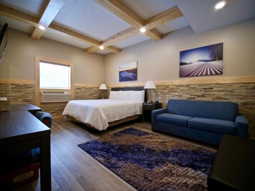 a hotel room with a bed, couch and a television at Caberfae Peaks Ski & Golf Resort in Harrietta