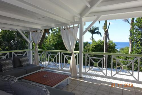 a porch with a couch and a view of the ocean at GREEN HOUSE in Deshaies