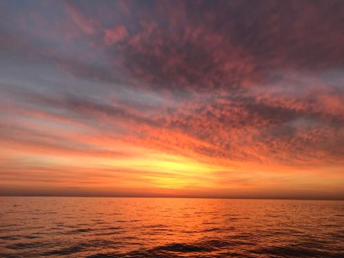 a sunset over a body of water at TO VOTSALO-beach side studios & taverna in Karpathos Town
