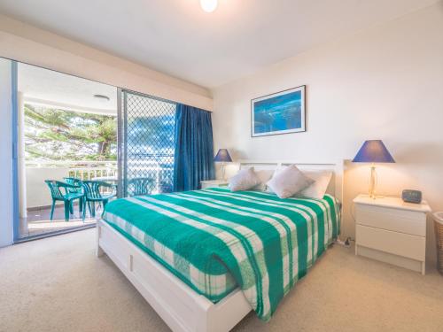 a bedroom with a bed and a balcony at Seaspray U4 21 Warne Tce in Caloundra