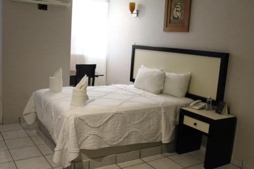 a bedroom with a white bed with a telephone at Hotel Florencia Poza Rica in Poza Rica de Hidalgo